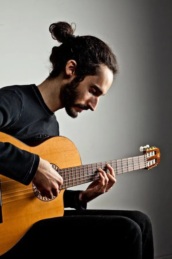 Promo photo of spoken word artist Nathanael Larochette playing his Classical guitar